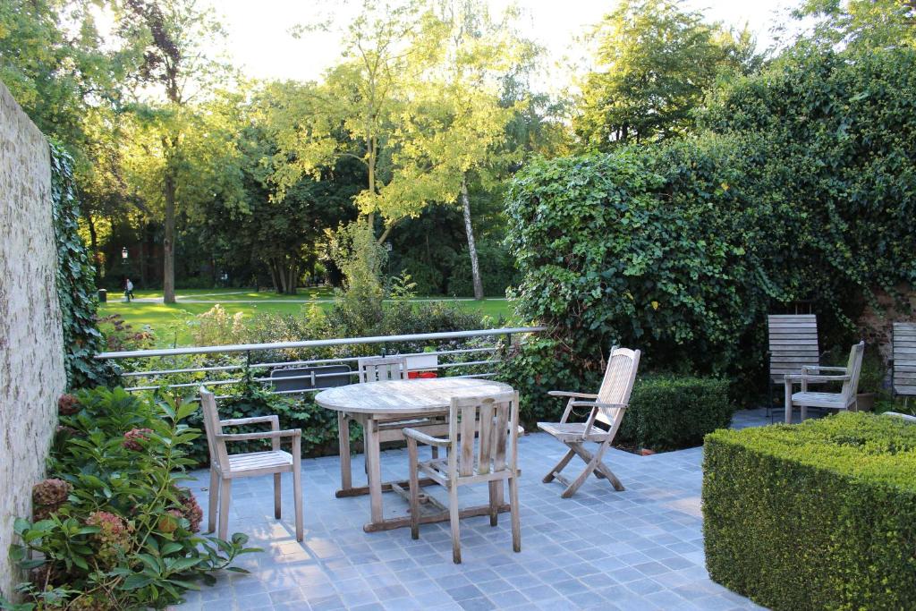 einen Tisch und Stühle auf einer Terrasse in der Unterkunft B&B Koetshuis in Brügge