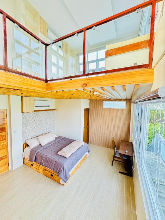 a bedroom with a large bed and a balcony at Dylan's Penthouse in San Fernando