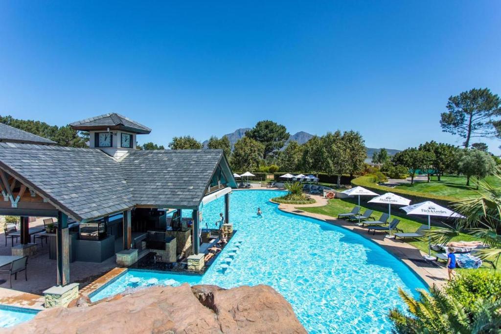 a pool at a resort with chairs and umbrellas at Luxury Lodge 4F Pearl Valley Golf Estate in Simondium