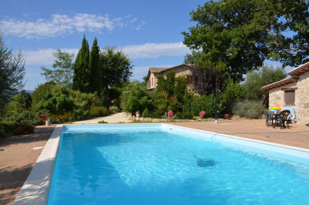 a large blue swimming pool in a yard at Casale il Cerqueto in San Severino Marche