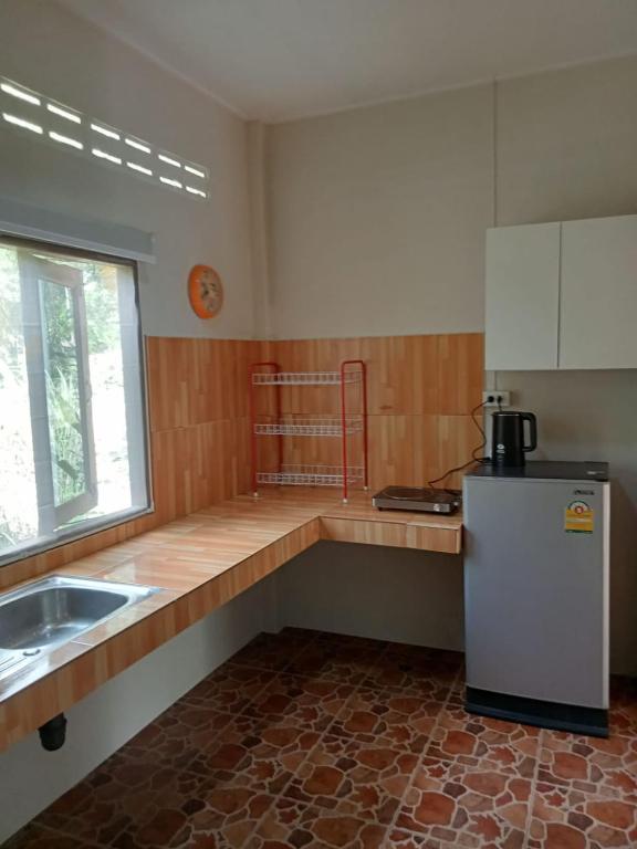 a kitchen with a counter and a refrigerator in it at KPG Baan Tai 2 in Ban Tai