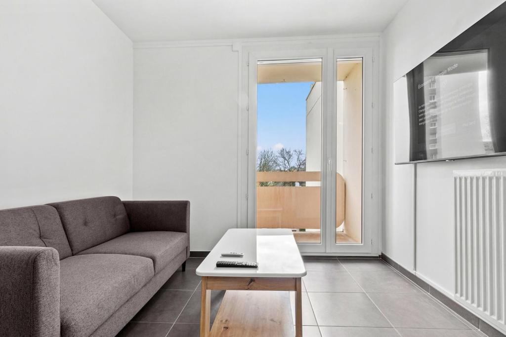 un salon avec un canapé et une table basse dans l'établissement Appartement Spacieux et Confort, à La Roche-sur-Yon
