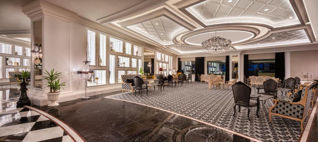 a dining room with chairs and tables and a chandelier at Delphin Imperial Lara in Lara