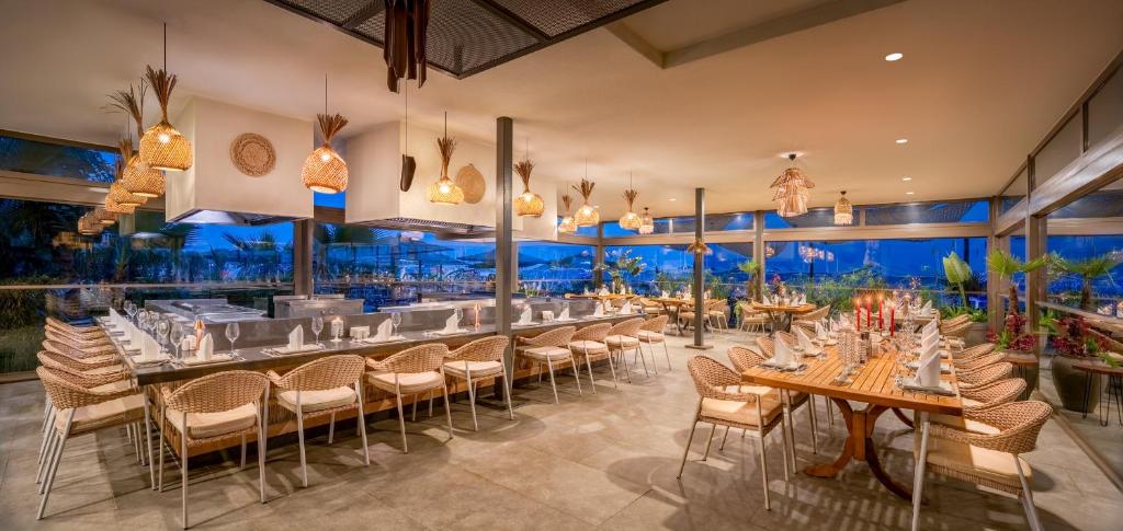 a restaurant with tables and chairs and a bar at Delphin Imperial Lara in Lara