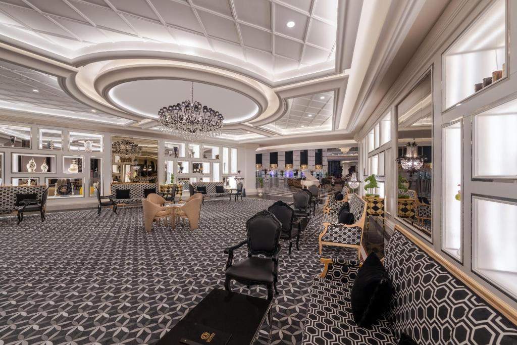 a large lobby with chairs and a chandelier at Delphin Imperial Lara in Lara