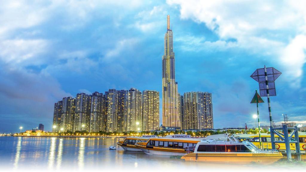 a city with boats in the water with a tall building at Vinhomes Central Park Apartment - Landmark Plus Luxury in Ho Chi Minh City