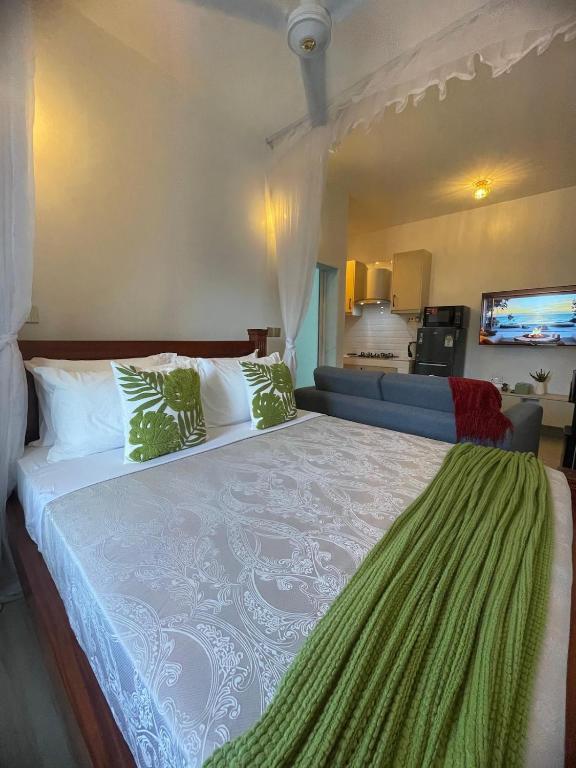 a bedroom with a large bed and a couch at Zuri Twin Sands Beach Properties - Malindi in Malindi
