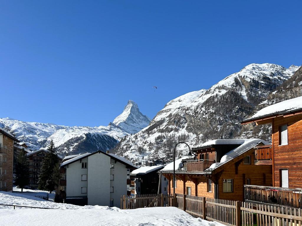 Une montagne enneigée au fond d'un village dans l'établissement Flat with magnificent views of the Matterhorn, à Zermatt