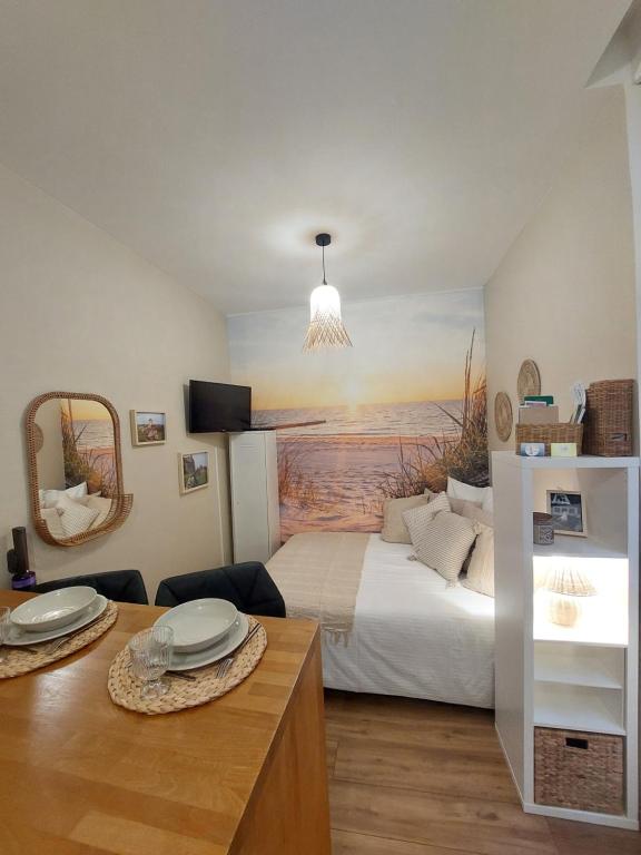 une chambre avec un lit avec un tableau sur le mur dans l'établissement Studio Saint Rémy Dieppe, à Dieppe