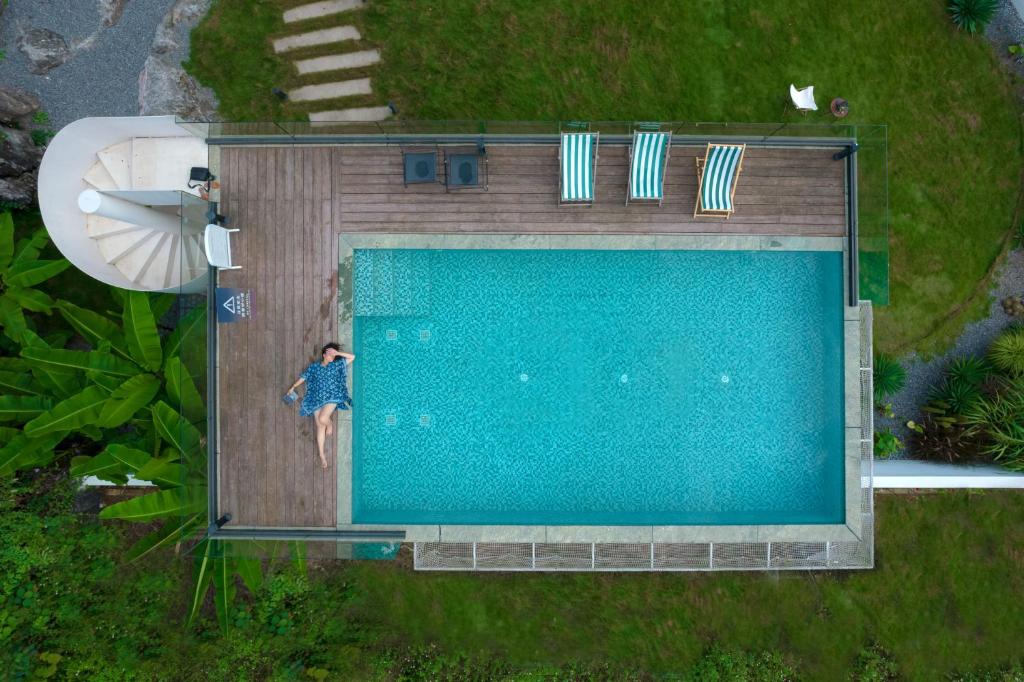 an overhead view of a woman swimming in a swimming pool at Yangshuo One Thousand and One Courtyard Views B&B in Yangshuo