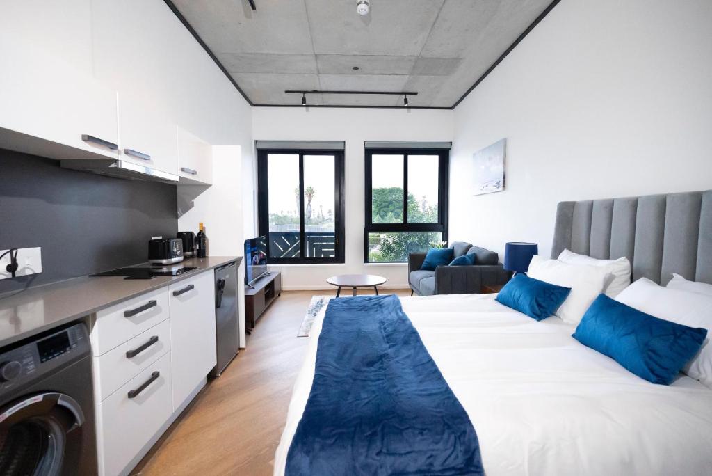 a bedroom with a large bed with blue pillows at Bridgewater Studio Century City in Century City