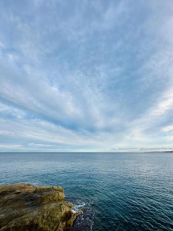 - une vue sur une grande étendue d'eau avec une falaise dans l'établissement Appartement 6 personnes au coeur d'ALGAJOLA, à Algajola
