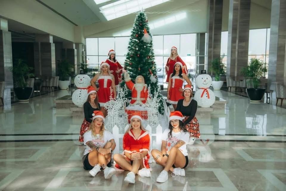a group of women posing in front of a christmas tree at Tiba Golden Beach Resort, Down Town in Hurghada