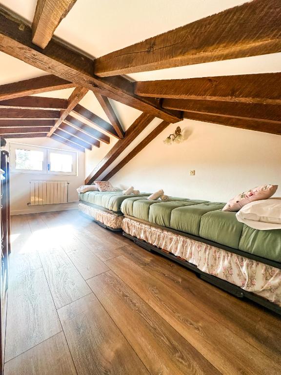 a row of beds in a room with wooden ceilings at casa rural cobreces in Cóbreces