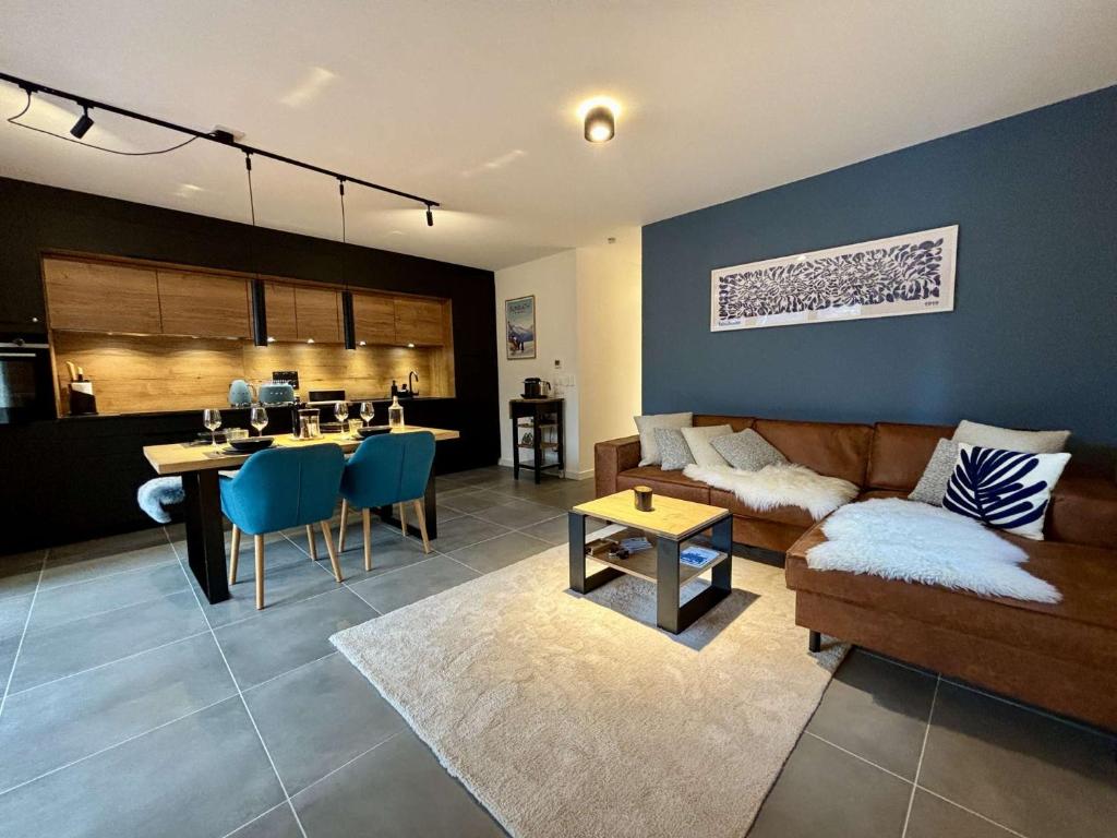 un salon avec un canapé et une table et une cuisine dans l'établissement Alchimie C11 - Multipass inclu, à Châtel