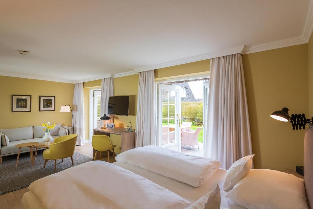 a hotel room with two beds and a window at Benen-Diken-Hof in Keitum