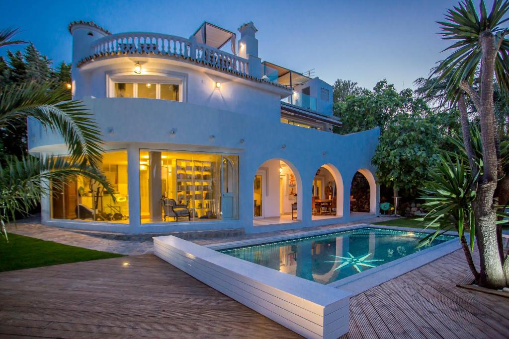 ein großes Haus mit einem davorliegenden Swimmingpool in der Unterkunft VillaCINCO in Sitio de Calahonda