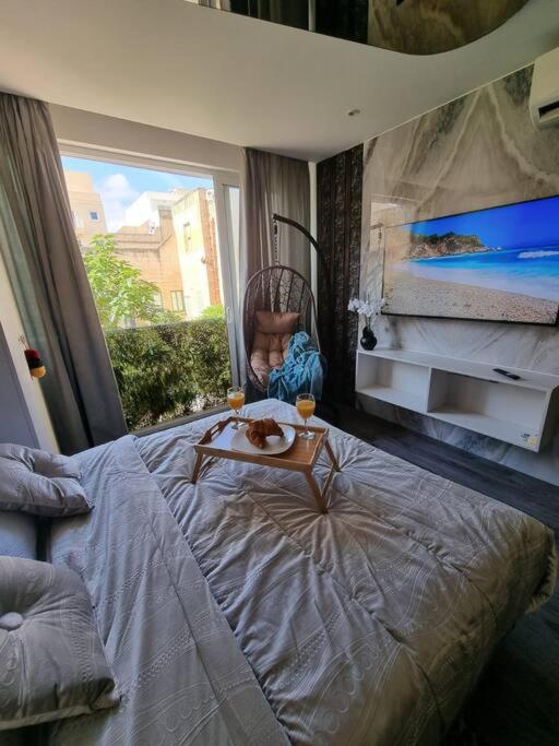 Un dormitorio con una cama grande y una mesa. en Coast Haven 203 Sliema Malta, en Sliema