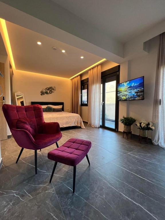 a large bedroom with a bed and a red chair at Adas Aura - Boutique Apartments in Old Town Thessaloniki in Thessaloniki