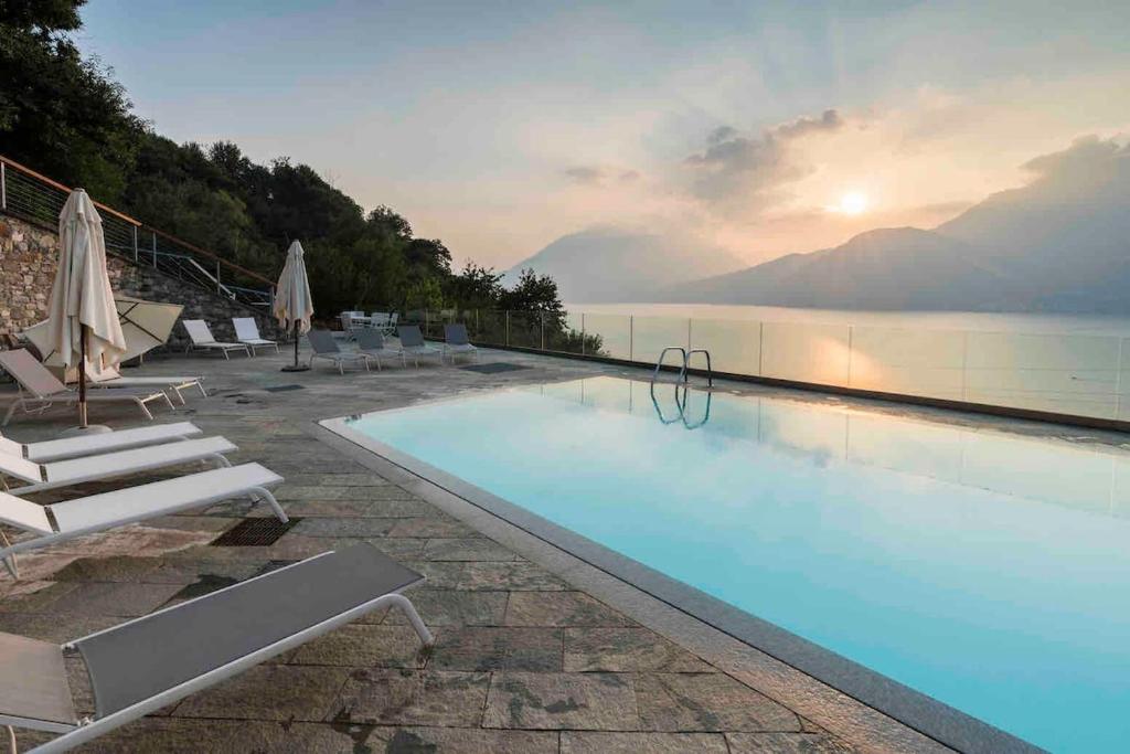 a swimming pool with chairs and a view of the water at house with 3 bedrooms T5 in Bellano