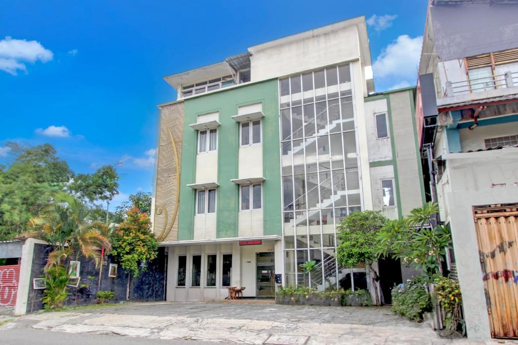 a green and white building on a street at Collection O Jalan Malioboro Near Lempuyangan Station Formerly Hotel Vala in Yogyakarta