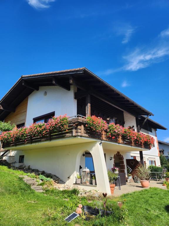 a house with a balcony with flowers on it at Ferienwohnung Panoramablick in Wertach