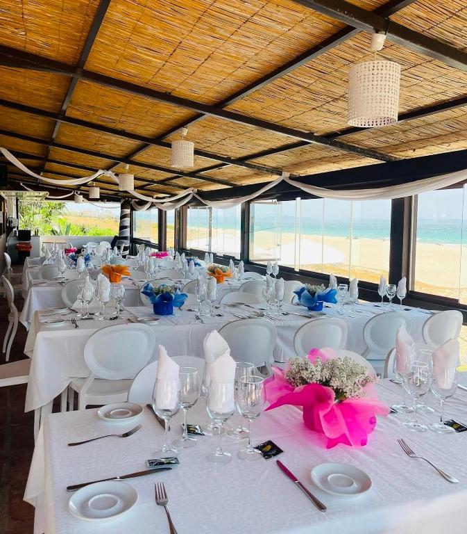 a table with white tables and chairs with flowers on it at Hostal Rios in Bolonia