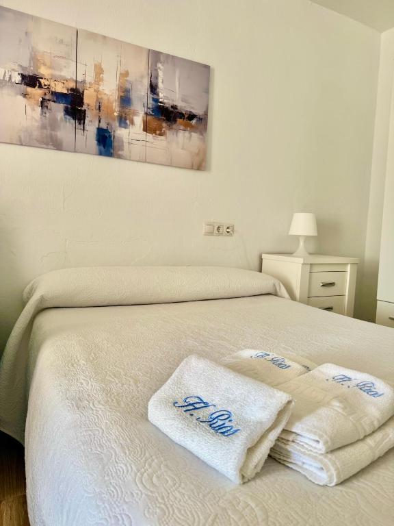 a bedroom with a bed with two towels on it at Hostal Rios in Bolonia