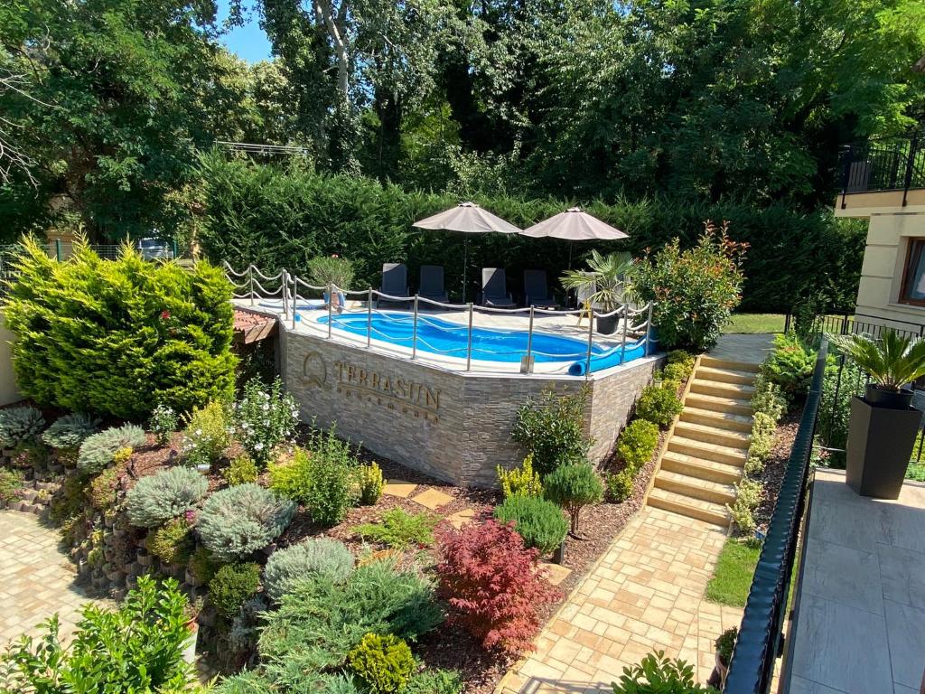 a swimming pool in a garden with plants at Terrasun Apartments in Balatonszárszó