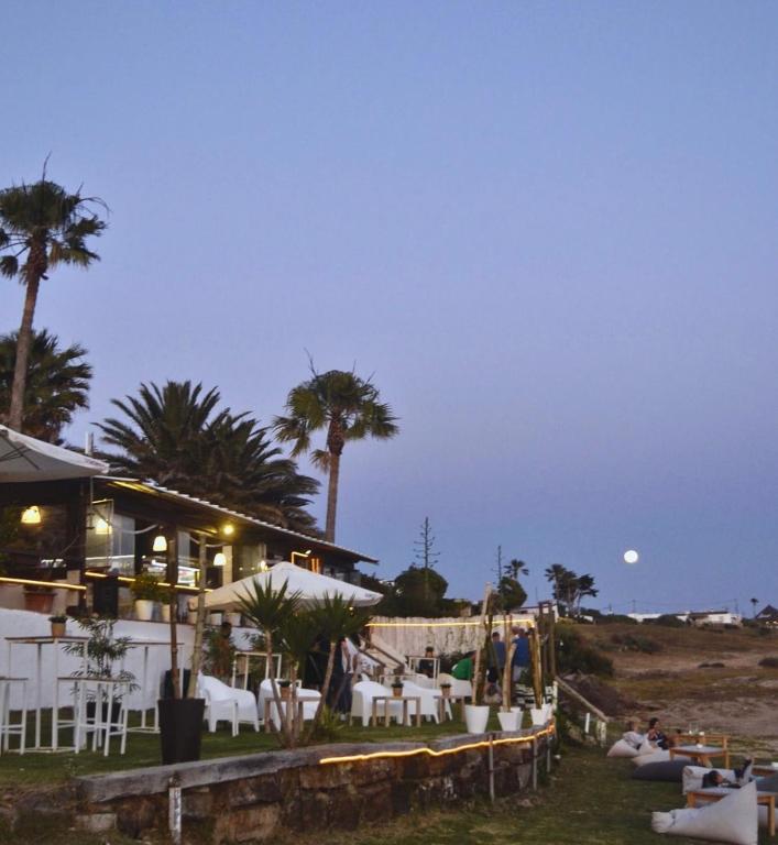 a restaurant with palm trees and a beach at night at Hostal Rios in Bolonia