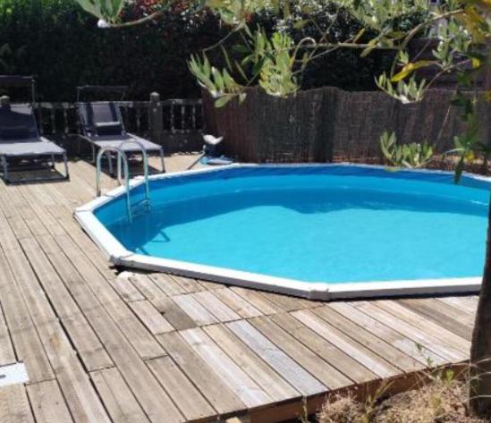 - une petite piscine bleue sur une terrasse en bois dans l'établissement La néo-bretonne forestière, à Camors