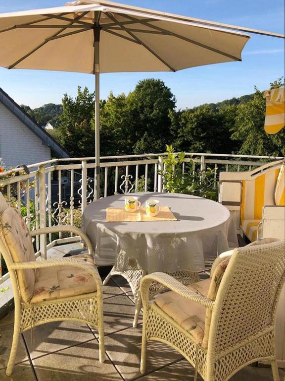 a table and chairs with an umbrella on a patio at Apartment Wallberg "Nest" in Detmold