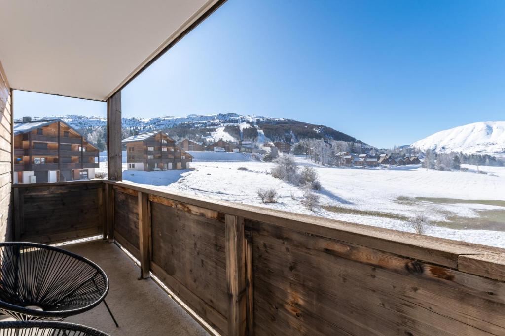 a balcony with a view of the snow covered mountains at Appartement pour 6, 700m des pistes de ski in La Joue du Loup