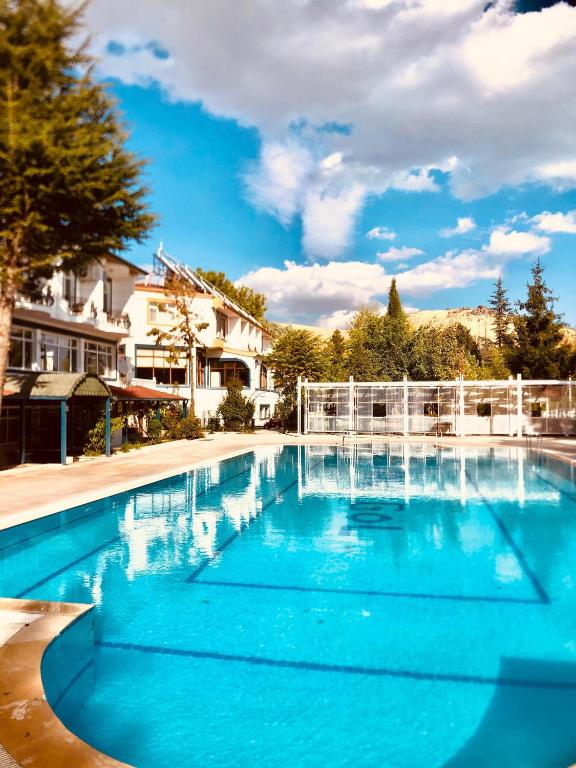 a large swimming pool with blue water at Elazığ Mavigöl Otel in Sivrice