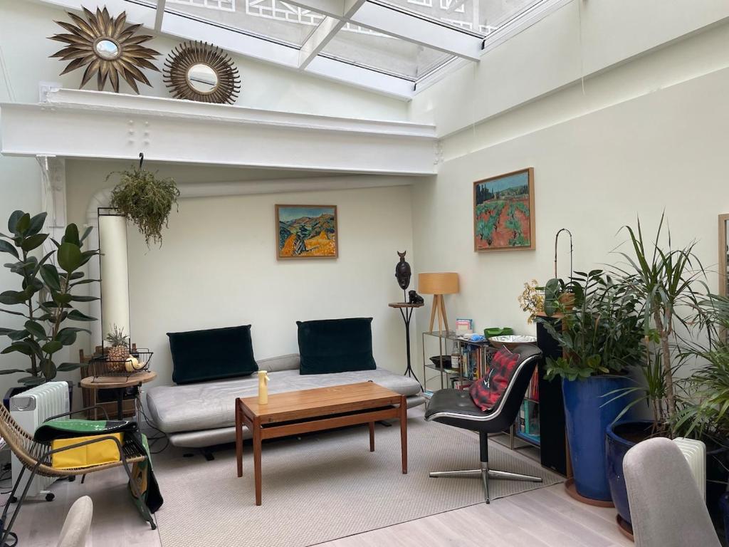 un salon avec un canapé, une table et des chaises dans l'établissement Entire Apartment Jardin du Luxembourg, à Paris