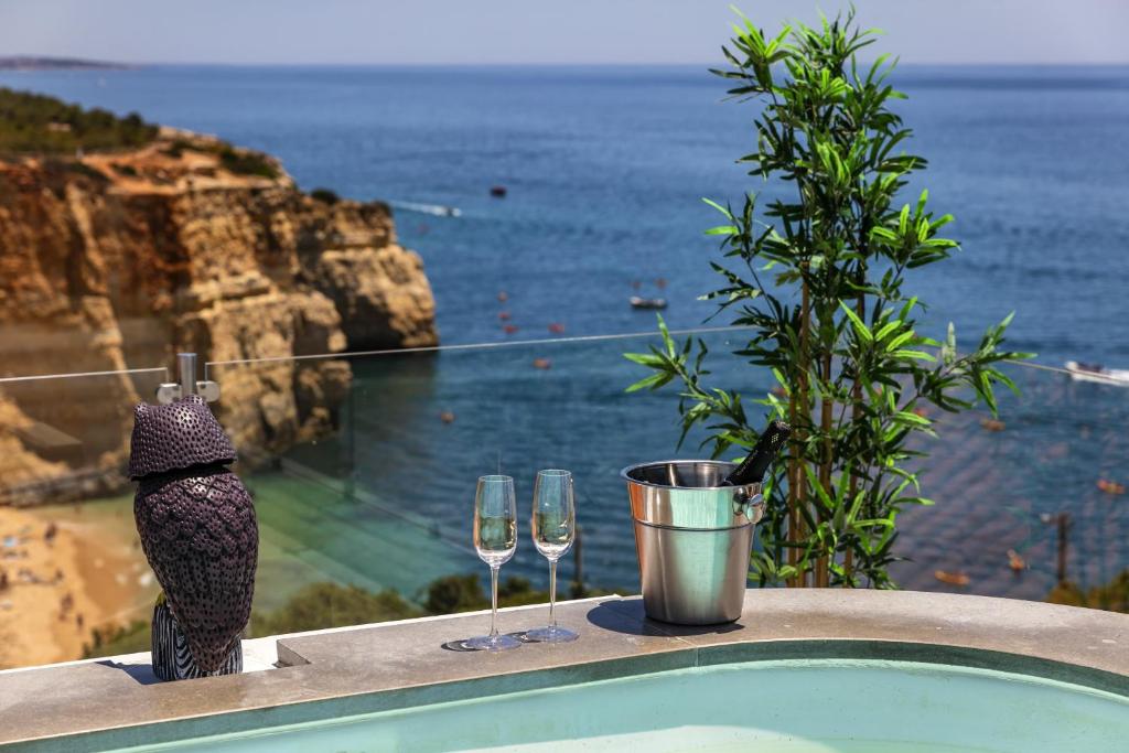 two glasses of wine on a ledge with a view of the ocean at Penthouse Milhafre in Benagil