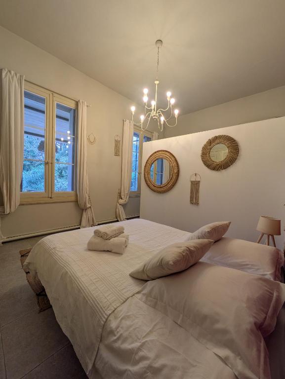 a bedroom with a large bed and a chandelier at Château Sainte Colombe in Saint-Geniès-des-Mourgues