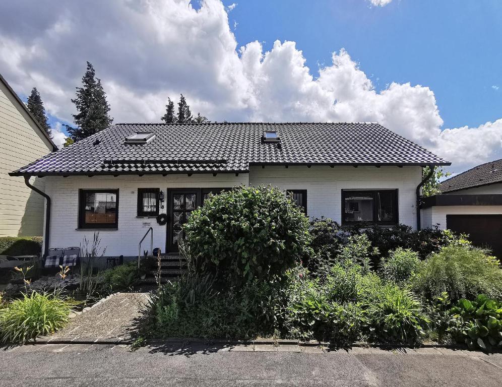 ein weißes Haus mit einem schwarzen Dach in der Unterkunft Ferienwohnungen Vesteblick in Dörfles