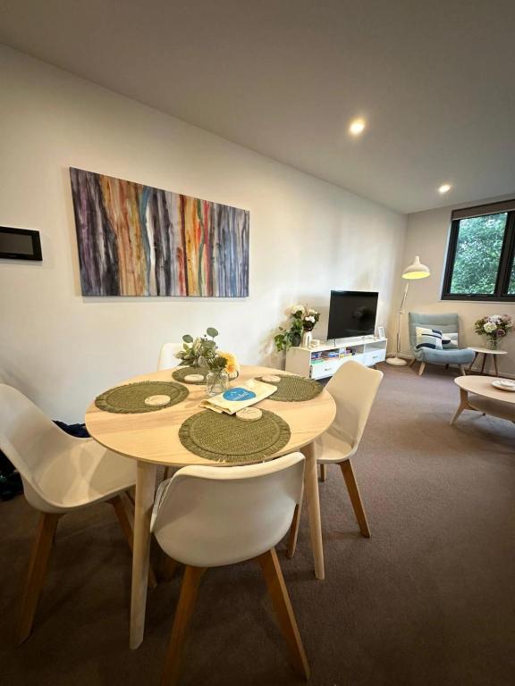 a dining room with a table and white chairs at Cosy getaway in the Heart of Braddon - Hosted by Canstay in Canberra