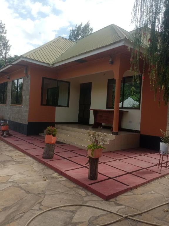 a home with two potted plants in front of it at Miroshi Camp Site in Sanya Juu