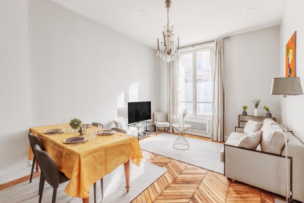 un salon avec une table et un canapé dans l'établissement Charmant Appartement 4P- Face ARC de Triomphe, à Paris