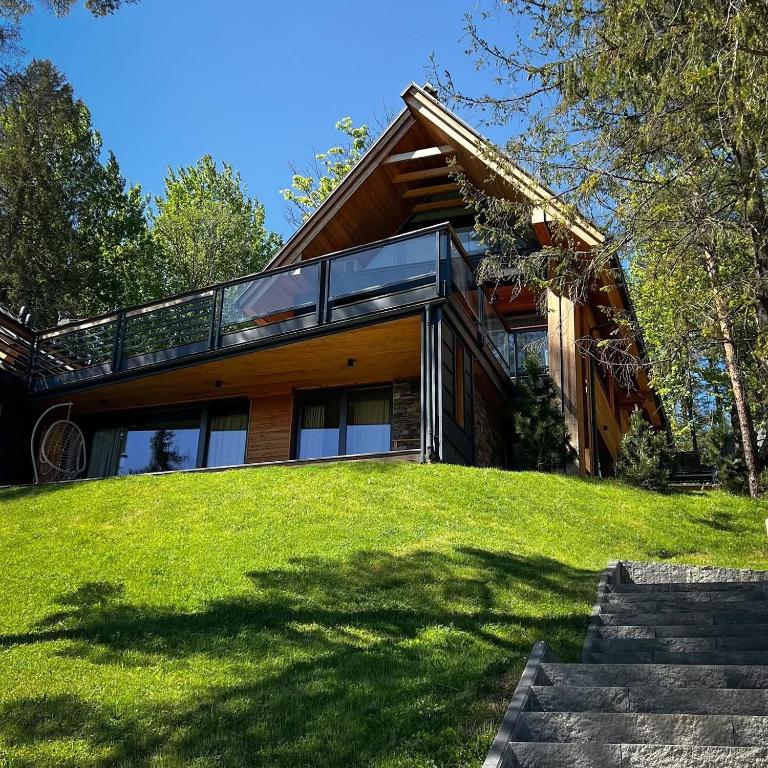 a house on top of a grassy hill at Apartament Białka SKI - 200m do Term Bania, blisko natury in Białka Tatrzańska