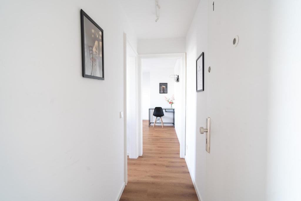 Un pasillo con paredes blancas y suelos de madera. en Wohnung im Zentrum von Koblenz, en Coblenza