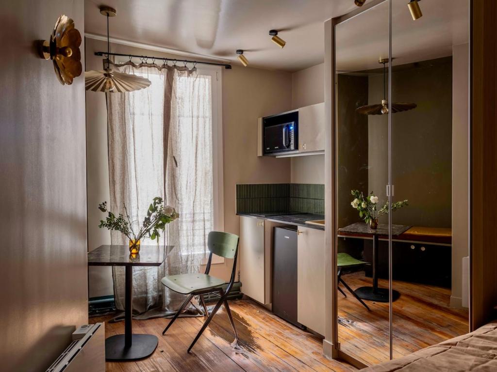 une petite pièce avec un lit, une table et des chaises dans l'établissement Lovely studio in the heart of Montmartre, à Paris