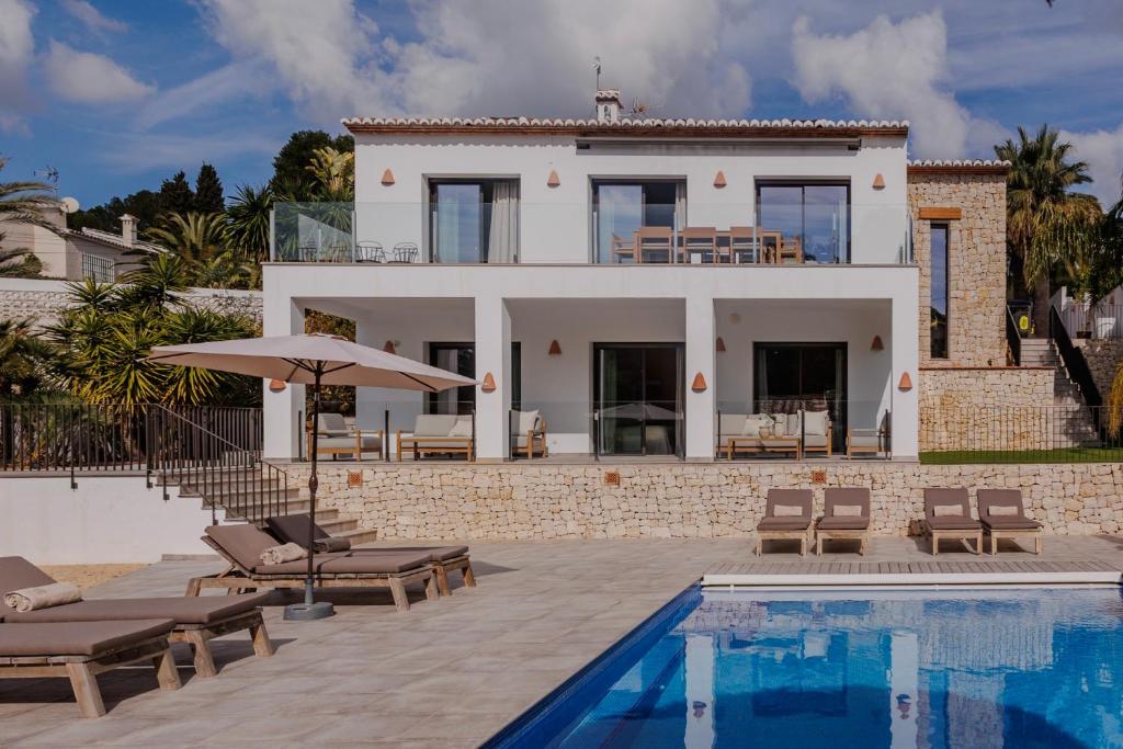 a villa with a swimming pool and a house at The Villa by Los Limoneros in Teulada