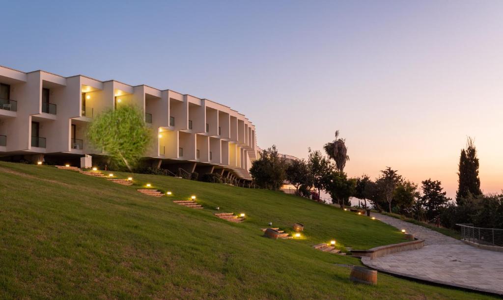 a building on a hill with lights in the grass at Elma Hotel and Art Complex in Zikhron Ya'akov