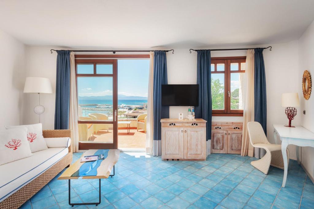 salon z kanapą i stołem w obiekcie Hotel Resort & Spa Baia Caddinas w mieście Golfo Aranci