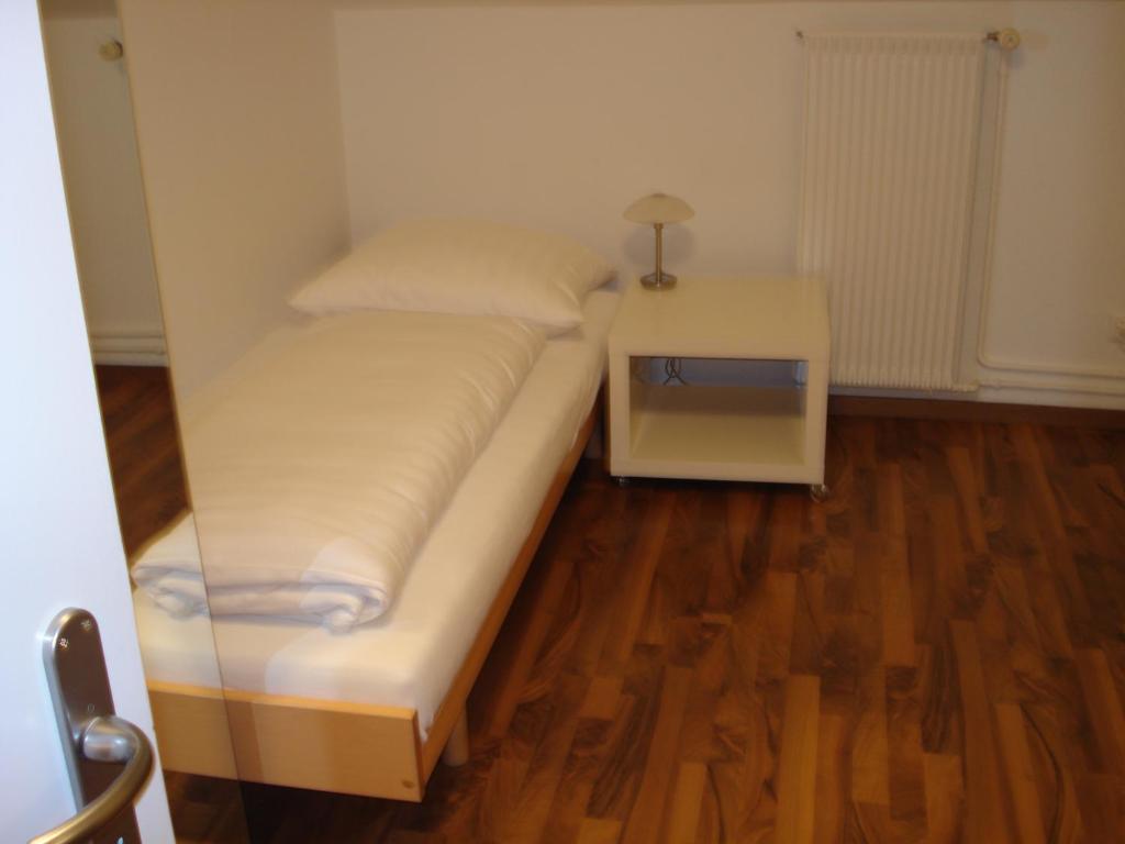a small bedroom with a bed and a night stand at Hotel Gregory in Zürich
