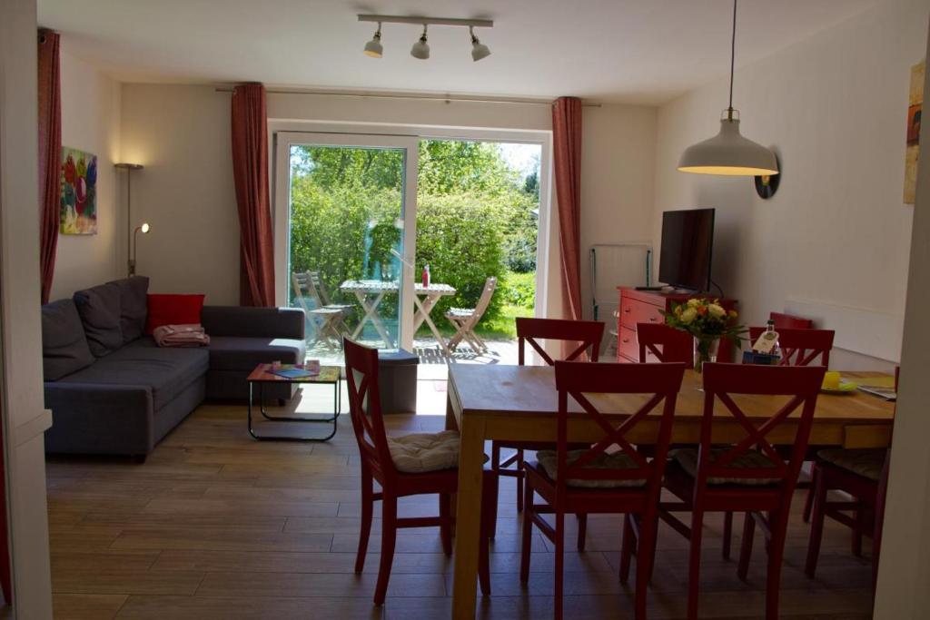 Una cocina y una sala de estar con mesa y sillas. en Inselblume 27 - Modernes Ferienhaus mit Garten in Burg, en Burg auf Fehmarn