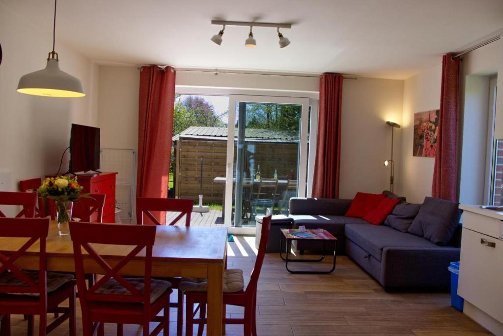 a living room with a table and a blue couch at Inselblume 28 - Ferienhaus mit Garten in Burg auf Fehmarn in Burg auf Fehmarn